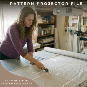 May include: A woman using a rotary cutter to cut fabric on a large cutting mat. A projector is mounted above, projecting a pattern onto the fabric. The text "PATTERN PROJECTOR FILE" and "COMPATIBLE WITH PATTERNPROJECTOR.COM" are visible.