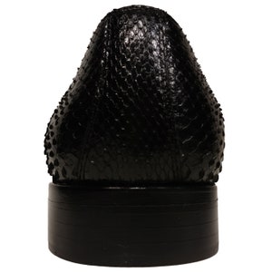 May include: Black leather dress shoe with a textured snakeskin pattern on the upper and a black rubber sole.