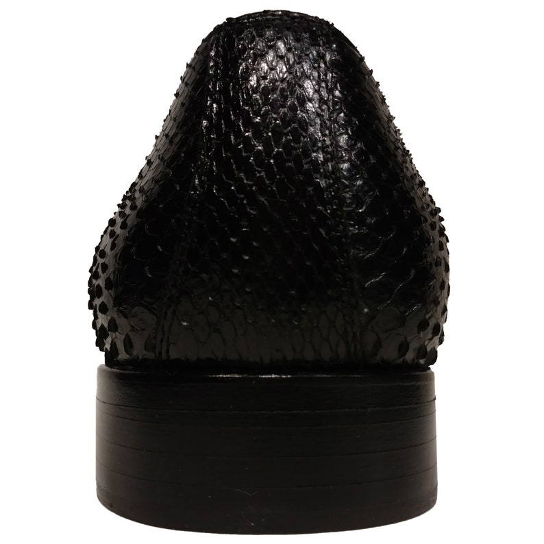 May include: Black leather dress shoe with a textured snakeskin pattern on the upper and a black rubber sole.