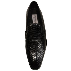 May include: Black leather slip-on shoes with a snakeskin pattern. The shoes have a pointed toe and a low heel. The brand name "RONALDO" is visible on the inside of the shoe.