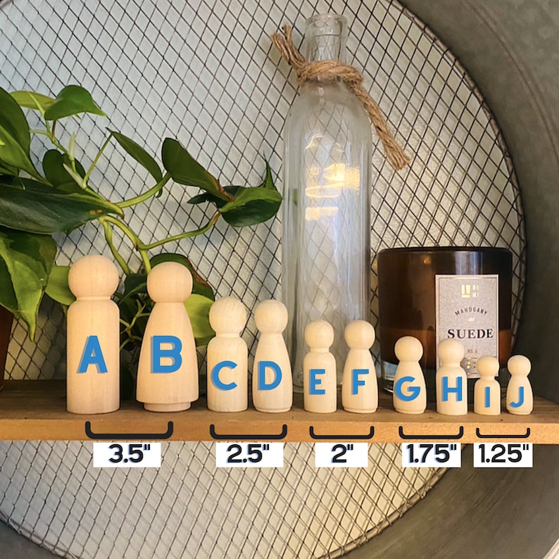 May include: A set of ten wooden peg dolls in various sizes, ranging from 1.25 inches to 3.5 inches tall. The dolls are unpainted and have a natural wood finish. The dolls are labeled with letters A through J, and the sizes are indicated below the dolls.
