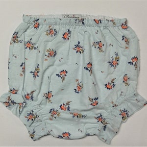 Puede incluir: Bombacho de beb&eacute; azul claro con estampado floral y cintura el&aacute;stica blanca. El bombacho tiene un borde con volantes y dice "Bonjour" en la cintura.