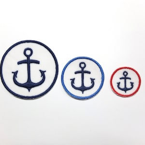 Könnte beinhalten: Drei runde Aufnäher mit einem Anker-Design. Die Aufnäher sind weiß mit einem marineblauen Anker in der Mitte. Der größte Aufnäher hat einen marineblauen Rand, der mittlere einen blauen Rand und der kleinste einen roten Rand.