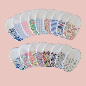 Puede incluir: Veinticuatro discos de algodón blanco con bordes festoneados. Cada disco tiene una tela estampada diferente cosida en el centro. Los patrones incluyen estampados florales, rayas, vichy y lunares en tonos de azul, rosa y blanco.