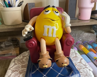 Vintage Yellow M&M Candy Dispenser in Recliner
