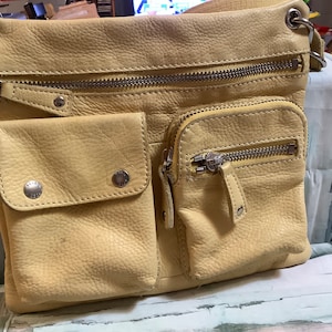 Bolso vintage Fossil de color amarillo pálido. 4 compartimentos diferentes con cremallera o broche. cuero muy suave