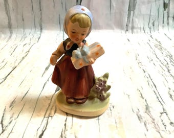 Vintage servies van napcoware Een klein meisje met cadeau.
