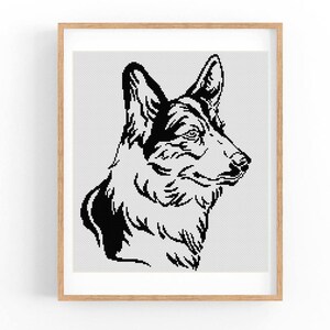 Op de afbeelding: Een ingelijst kruissteekpatroon met een zwart-witte grafische illustratie van een Duitse herdershondenkop in profiel. Het ontwerp is samengesteld uit kleine, duidelijke vierkante steken op een witte rasterachtergrond, gevat in een licht houten lijst.