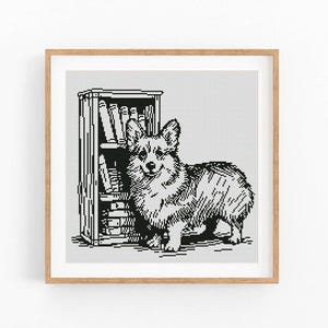 May include: A black and white cross stitch pattern featuring a Corgi dog standing next to a tall, narrow bookshelf filled with books. The design is presented within a square wooden frame, showcasing a detailed pixelated illustration of the dog.