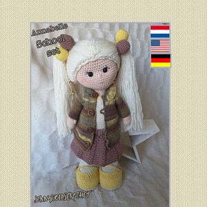 Op de afbeelding: Gehaakte pop met blond haar, die een bruin en geel gestreept vest, een bruine rok en gele schoenen draagt. De pop is gelabeld met "Annabelle School set" en "Jennydollscrochet".