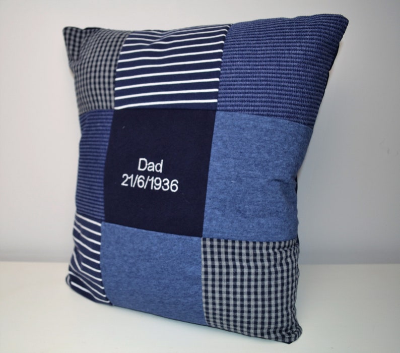 May include: A blue and white patchwork pillow with the text "Dad 21/6/1936" embroidered on the front.