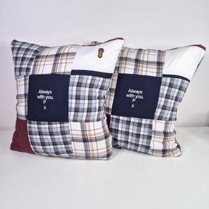 May include: Two square patchwork pillows with a blue, white, and brown plaid pattern. The pillows have a navy blue square with white text that reads "Always with you P x".