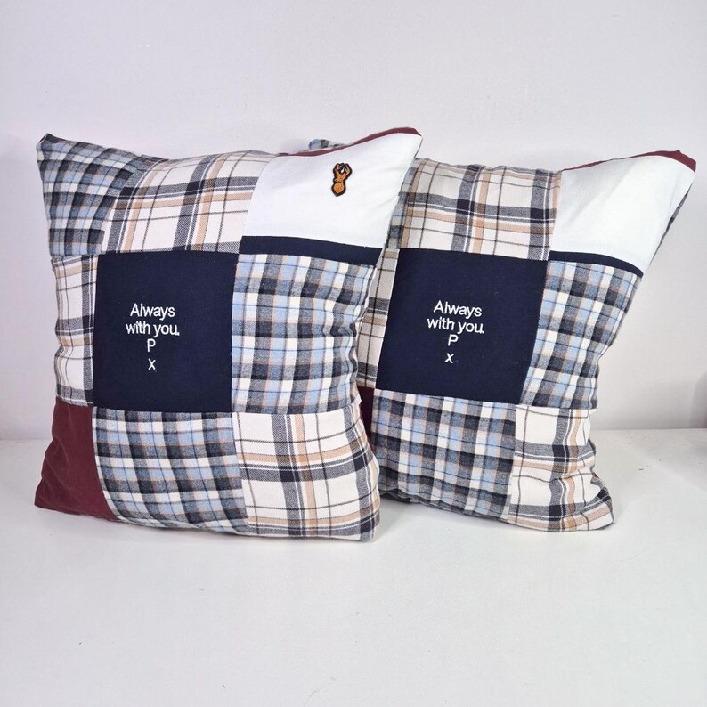 May include: Two square patchwork pillows with a blue, white, and brown plaid pattern. The pillows have a navy blue square with white text that reads "Always with you P x".