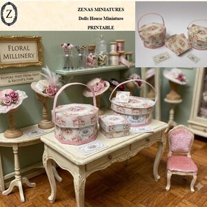 Può includere: Una collezione di accessori in miniatura per case delle bambole che include cappelliere con motivi floreali, piccole scatole quadrate e cappelli decorativi su supporti. Gli articoli presentano stampe di rose rosa e verdi. Il testo sulla parete recita Floral Millinery e Bespoke Hats From Kent & Regent's Park. Zenas Miniatures Dolls House Miniature Printable.