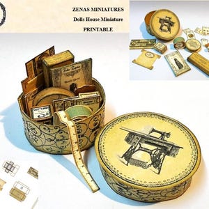 Könnte beinhalten: Miniatur-Nähzubehör für ein Puppenhaus, darunter eine runde Schachtel mit einer Nähmaschinen-Illustration, Garnrollen und kleine Bücher. Die Schachtel ist geöffnet und zeigt weitere Miniaturartikel. Der Text "ZENAS MINIATURES" ist sichtbar.