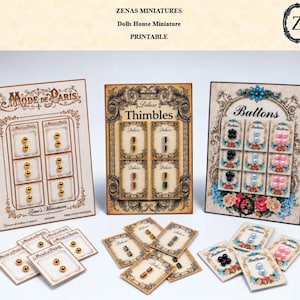 May include: Three rectangular display cards featuring miniature sewing supplies: gold beads labelled Mode de Paris, metallic thimbles labelled Deluxe Thimbles, and colourful buttons labelled Buttons. Includes individual smaller cards with matching items.