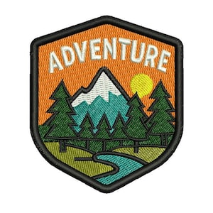 Op de afbeelding: Geborduurde patch in schildvorm met het woord "ADVENTURE" in het wit. Het ontwerp toont een bergketen, dennenbomen, een gele zon en een rivier, alles tegen een oranje achtergrond.