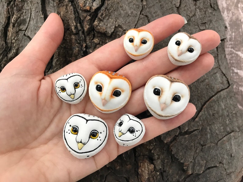 May include: A collection of seven hand-painted ceramic owl figurines. The owls are all different sizes and have realistic features, including eyes, beaks, and feathers. Some of the owls are white with black markings, while others are brown with orange markings.