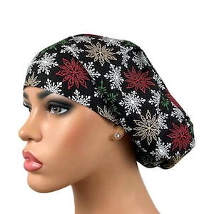 May include: Black scrub hat with a snowflake pattern in red, gold, and green. The hat is made of a soft, comfortable fabric and is perfect for nurses, doctors, and other healthcare professionals.