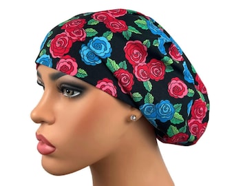 May include: A black bouffant scrub cap featuring a vibrant floral pattern. The design includes red, pink, and blue roses with green leaves. The cap is designed to cover the hair and is likely for medical or beauty professionals.
