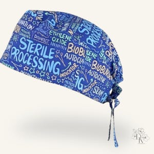 May include: A blue scrub cap featuring a repeating pattern of medical-themed text including Sterile Processing, Bioburden, Autoclave, and Ethylene Oxide in light blue and white lettering, with fabric ties at the back for an adjustable fit.