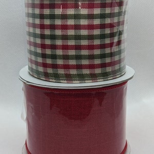 May include: Two spools of ribbon, one red and one plaid with red, green, and white squares.