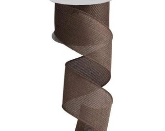 May include: A roll of brown ribbon with a woven texture. The ribbon is unwound in a spiral, revealing its width and texture. The spool is white. This ribbon is suitable for crafts, gift wrapping, and decorative purposes.