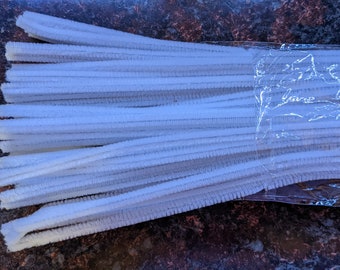 May include: A package of white pipe cleaners. The pipe cleaners are bundled together and wrapped in clear plastic.