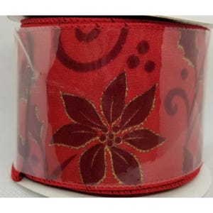 May include: Red ribbon with a gold and burgundy poinsettia pattern. The ribbon is wrapped around a spool and is ready to be used for wrapping gifts or decorating.