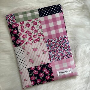 Op de afbeelding: Een patchwork stoffen tasje met een roze en wit ruitjespatroon, bloemenprints en stippen. Het tasje heeft een wit label met de tekst "Always September".
