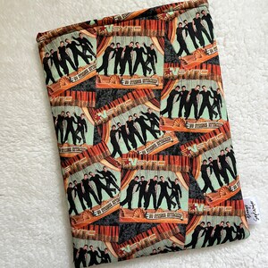 May include: A black and white fabric with a repeating pattern of a band performing on stage. The band is called "NSYNC" and the album cover says "No Strings Attached".