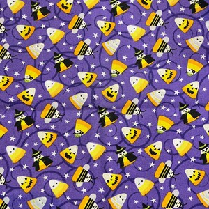 May include: Purple fabric with a repeating pattern of yellow and white candy corn, black witches, and yellow and black bees. The background is a light purple with white stars.