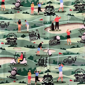 Op de afbeelding: Een groene en witte stof met een herhalend patroon van golfers, golfkarren en golfgerelateerde tekst. De tekst omvat "Golf Club", "Green Hills", "Golf Tournament", "Champions League" en "Golf Championship".