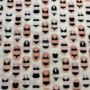 Könnte beinhalten: Ein weißer Stoff mit einem sich wiederholenden Muster aus schwarzen Dessous-Silhouetten. Die Dessous sind in einem Raster angeordnet, wobei sich jedes Dessous in einer separaten ovalen Form befindet. Der Hintergrund ist hellcremefarben.