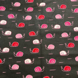 Può includere: Tessuto nero con un motivo ripetuto di lumache rosa e rosse, con dettagli di conchiglie bianche. Le lumache sono delineate in bianco e sono disposte con brevi linee orizzontali. Il design è stravagante e giocoso.