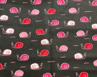 Peut inclure: Tissu noir avec un motif répété d'escargots roses et rouges, avec des détails de coquilles blanches. Les escargots sont soulignés en blanc et sont disposés avec de courtes lignes horizontales. Le design est fantaisiste et ludique.