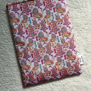 May include: A pink fabric pouch with a repeating pattern of colorful stars, eggs, and other objects. The pouch has a label that says "Stampy's Emporium".