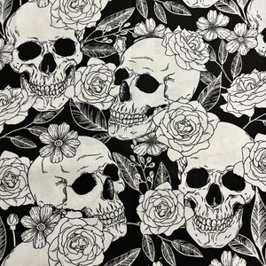 Puede incluir: Tela en blanco y negro con estampado de calaveras y flores. El diseño presenta dibujos lineales detallados de calaveras, rosas y otras flores, creando una estética gótica y romántica. Adecuado para proyectos de manualidades.