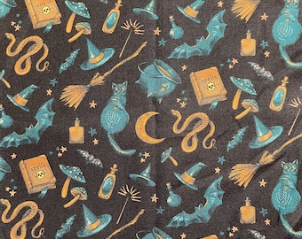 Peut inclure: Un tissu noir avec un motif répété d'éléments de sorcellerie, y compris des chats noirs, des chaudrons, des balais, des serpents, des chauves-souris, des champignons, des étoiles et un livre qui dit "Spells".