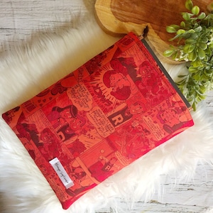 May include: Red and white comic book print zipped pouch with the text "HONEST" and "DU DREAM" on the front. The pouch is made of fabric and has a zipper closure.