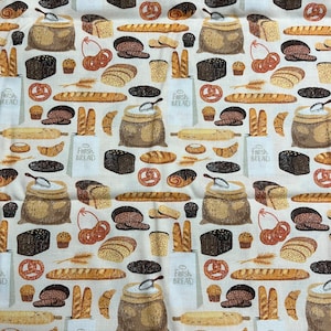 May include: A beige fabric with a repeating pattern of various baked goods, including loaves of bread, pretzels, croissants, and pastries. The pattern also includes bags of flour, rolling pins, and sprigs of wheat. The text "Fresh Bread" is repeated throughout the pattern.
