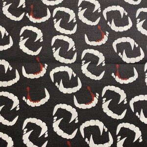 May include: Black fabric with a repeating pattern of white vampire fangs with red dripping blood.