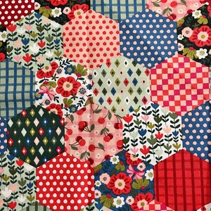May include: A patchwork quilt composed of hexagonal fabric pieces. The fabrics display floral, polka dot, gingham, and diamond patterns in red, blue, green, and pink. The quilt has a handmade, vintage aesthetic.