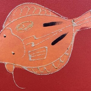 May include: A hand-painted orange fish with silver glitter details on a red background.