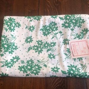 May include: White fabric with a green floral pattern. The fabric has small white dots and a label that reads "Premier Prints, Inc."