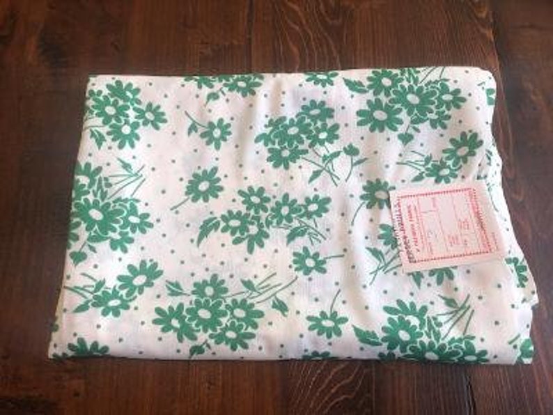 May include: White fabric with a green floral pattern. The fabric has small white dots and a label that reads "Premier Prints, Inc."