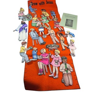 May include: An orange felt growth chart with the text Grow with Jesus, featuring black measurement markings. It includes various paper cutouts of children, a figure in a robe, a manger, and a small instructional booklet with a green cover.