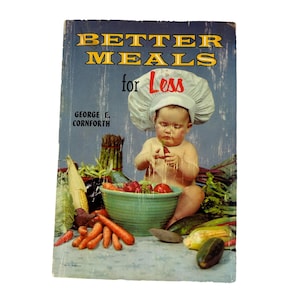 May include: A vintage cookbook cover featuring a baby wearing a chef's hat and holding a red pepper. The cover is titled "Better Meals for Less" with the author's name, George E. Cornforth, listed below. The baby is surrounded by a variety of vegetables, including carrots, corn, and eggplant.