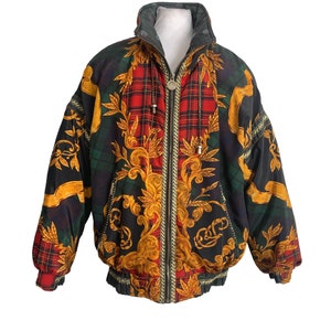 May include: A black, green, red, and gold patterned puffer jacket with a zipper closure.