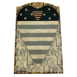May include: A wooden heart-shaped sign with a patriotic design. The heart is filled with a blue background with white stars and a red, white, and blue striped heart in the center. The background of the sign is a tan color with the word "Liberty" repeated in a stylized font.